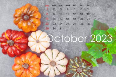 Ekim 2023 Takvim ve eski ahşap arka planda sonbahar yapraklı balkabakları.