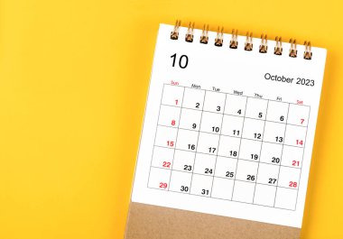 2023 yılının Ekim ayının masa takvimi sarı arka planda..