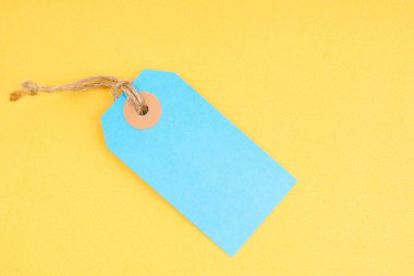 Sarı arka planda mavi renkli boş fiyat etiketi. Fiyat etiketi, hediye etiketi, satış etiketi olarak harika.