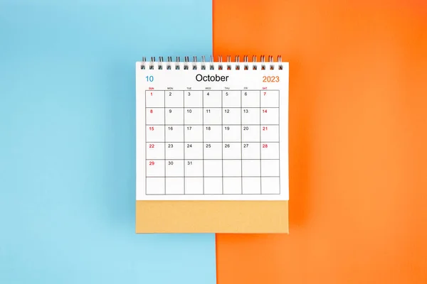 stock image Directly above view of October 2023 desk calendar on blue and orange background with copy space.