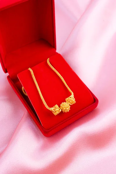 Collana Oro Una Scatola Rossa Uno Sfondo Tessuto Rosa — Foto Stock