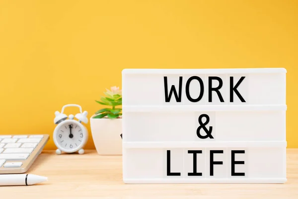 Work & Life written white lightbox on worktable. Work Life Balance concepts.