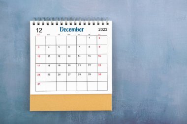 Aralık 2023 'ün tam üstünde mavi ahşap arkaplan ve kopyalama alanı olan masa takvimi.