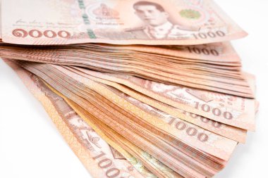 Beyaz arka planda Tayland baht banknotlarının yakın plan yığını.
