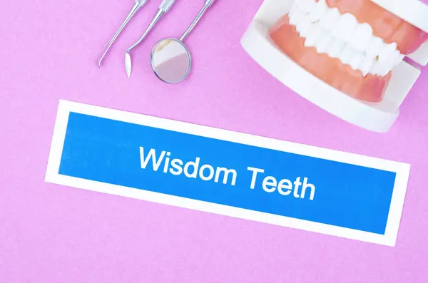 Wisdom Teeth dental disease and teeth model with tools on pink color background.