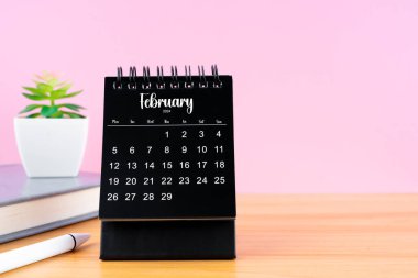 2024 yılı için Şubat Mini masa takvimi pembe arkaplanlı çalışma tablosu.
