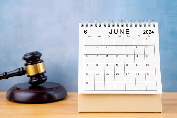 Desk calendar for June 2024 and judge\'s gavel on the worktable.