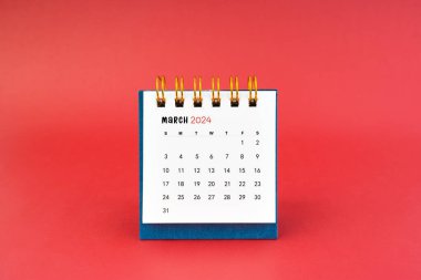 Kırmızı arkaplanda Mart 2024 beyaz masa takvimi.