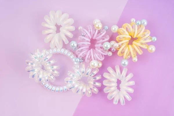 Colorful plastic hair elastics set on beautiful background.