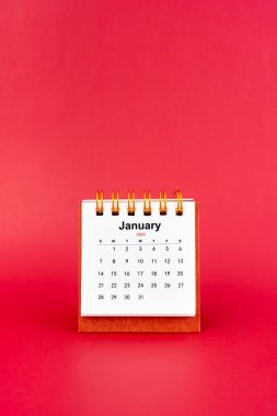 Ocak 2024 kırmızı arkaplan üzerine beyaz masa takvimi.