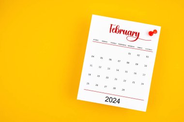Şubat 2024 takvim sayfası kırmızı düğmeli sarı zemin.