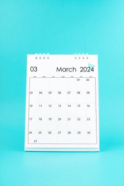 Mavi arkaplanda 2024 Mart beyaz masa takvimi.