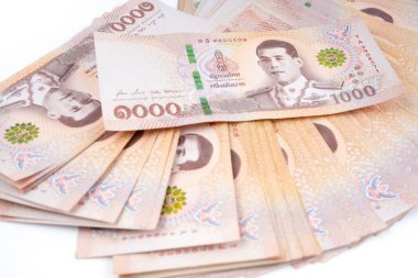 Beyaz arka planda Tayland baht banknotlarının yakın plan yığını.