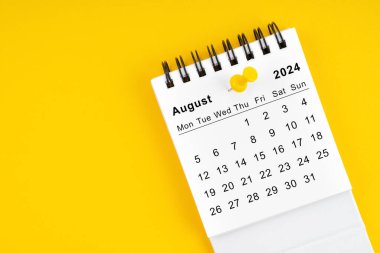 2024 Ağustos ayının masa takvimi. Sarı arkaplanda raptiye var..