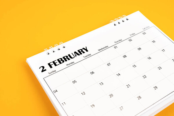 Февраль 2024 настольный календарь на желтом фоне. Концепции дня планирования времени.