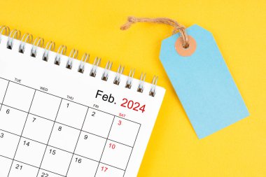 Şubat 2024 Sarı arka planda boş fiyat etiketli masa takvimi.