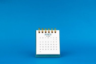 Mart 2024 mavi arkaplan üzerine mini masa takvimi.