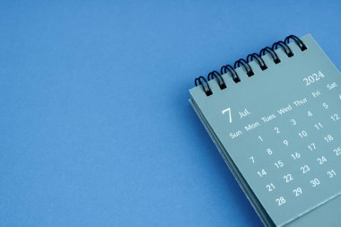 Mavi arkaplanlı Temmuz 2024 masa takvimi. Boşluğu kopyala.