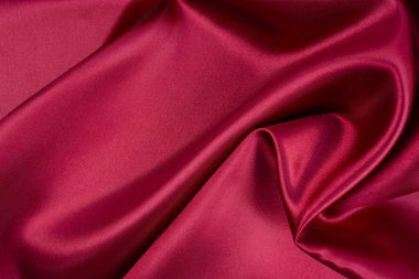 Arkaplan olarak koyu kırmızı saten dokusu.