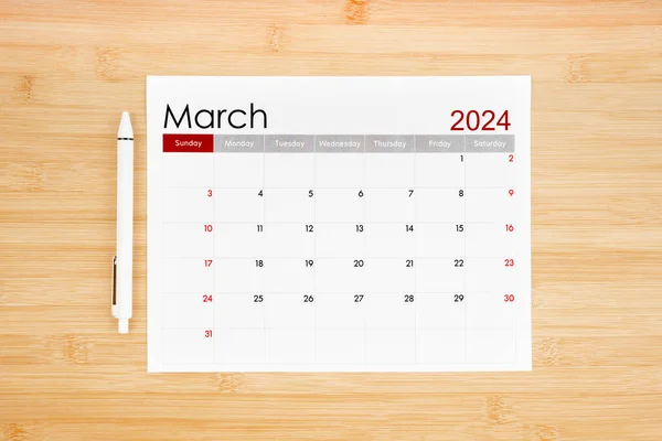 Stock image March 2024 calendar page on wooden background.