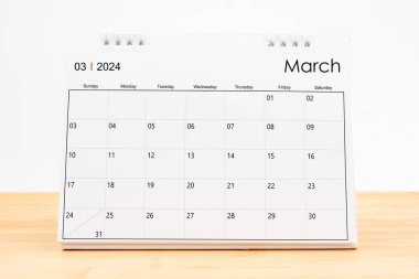 Aylık masa takvimi Mart 2024 Beyaz arka planlı ahşap masa üzerinde.