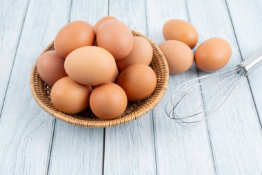 Tahta masadaki sepette taze çiğ yumurta..