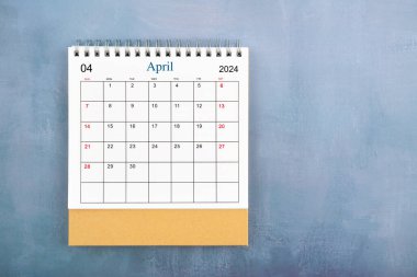 Nisan 2024 masa takviminin tam üstünde mavi ahşap arkaplan ve kopyalama alanı.
