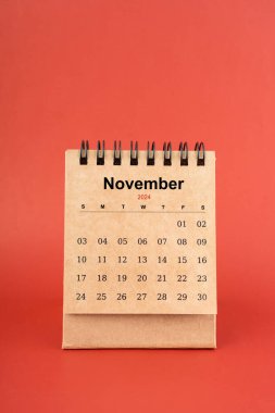 Kasım 2024 kırmızı arkaplan üzerine beyaz masa takvimi.