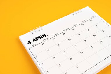Nisan 2024 sarı arkaplanlı masa takvimi. Zaman planlama günü kavramları.