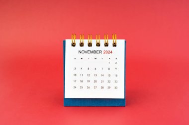 Kasım 2024 kırmızı arkaplanda beyaz masa takvimi.