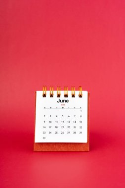 Haziran 2024 kırmızı arkaplan üzerine beyaz masa takvimi.