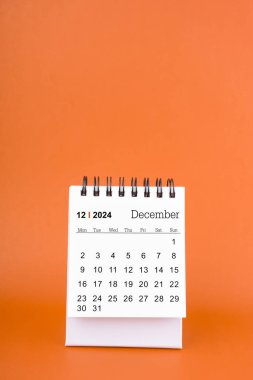 Turuncu arkaplanda Aralık 2024 dikey tablo takvimi.