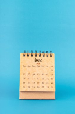 Haziran 2024 mavi arkaplan üzerine beyaz masa takvimi.