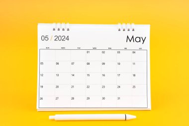 Mayıs 2024, 2024 yılı için aylık masa takvimi ve sarı arkaplan üzerine kalem.