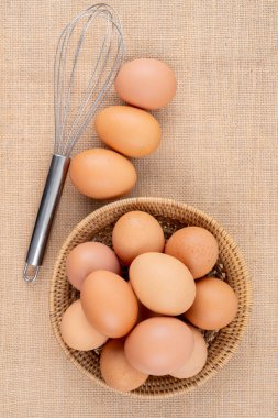 Arka planda dokuma sepetinde taze organik yumurtalar.