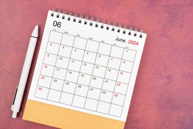 Kırmızı arkaplan üzerine Haziran 2024 masa takvimi ve kalem.