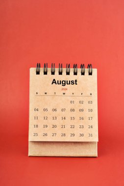 Ağustos 2024 kırmızı arkaplan üzerine beyaz masa takvimi.