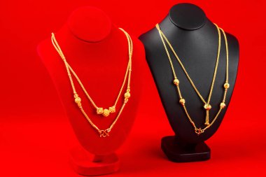 Aksesuar ve altın mücevher gerdanlığı kırmızı kadife kumaş üzerinde altın kolye.