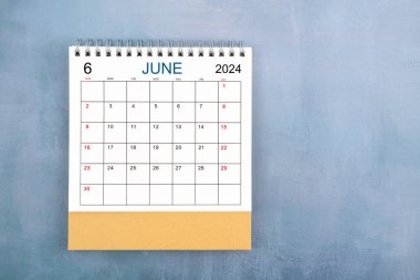 Mavi ahşap zemin üzerinde Haziran 2024 masa takviminin tam üstünde.