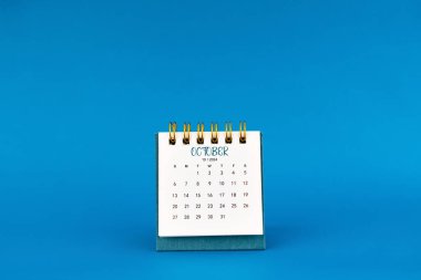 Ekim 2024 Mavi arkaplan üzerine mini masa takvimi.