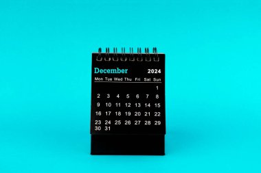 Aralık 2024 için Siyah Takvim. Yeşil arkaplan üzerindeki masaüstü takvimi.