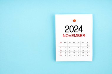 Kasım 2024 takvim sayfası mavi arkaplandaki iğneye basılı.
