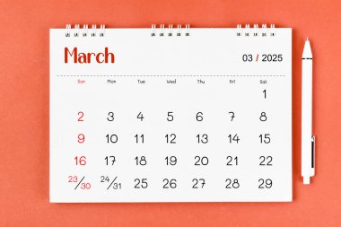 Mart 2025 2025 Aylık masa takvimi ve kırmızı arkaplan üzerine kalem.