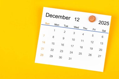 Aralık 2025 ve sarı arkaplanda ahşap raptiye.