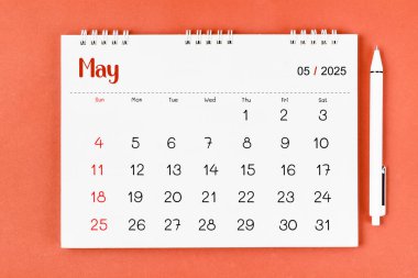 Mayıs 2025 Aylık masa takvimi 2025 ve kırmızı arka planda kalem.