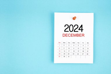 Aralık 2024 takvim sayfası mavi arkaplan üzerine pin basın.