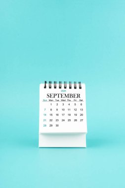 Eylül 2025 mavi arkaplan üzerine beyaz masa takvimi.