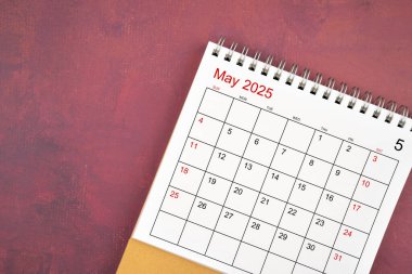 Kırmızı arkaplanda Mayıs 2025 masa takvimi.