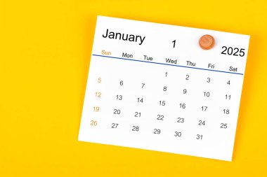 Ocak 2025 ve sarı arkaplanda tahta raptiye.