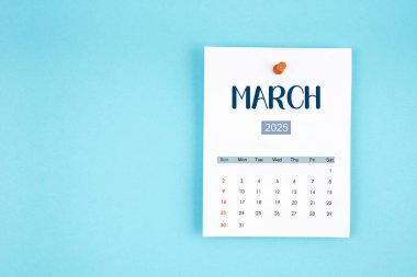 Mart 2025 takvim sayfası mavi arkaplan üzerine pin basın.